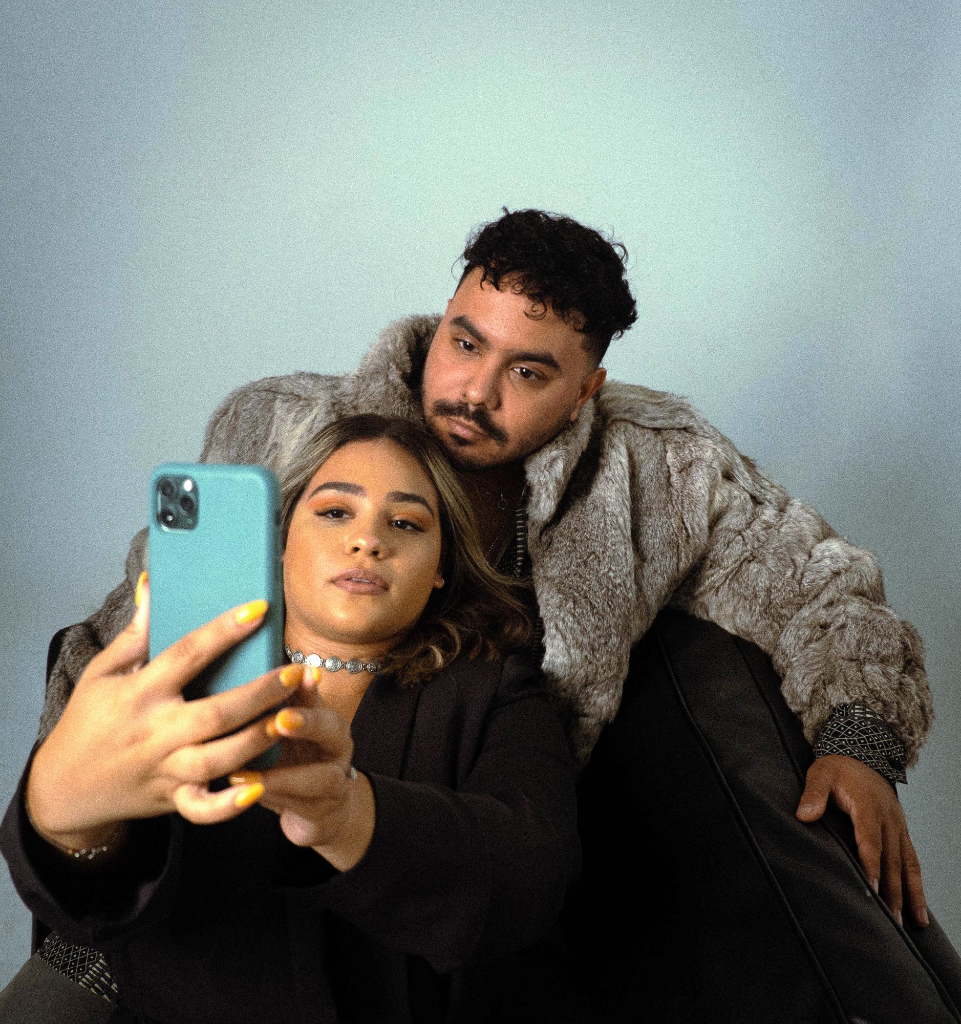 Engaged couple taking a selfie together in the studio